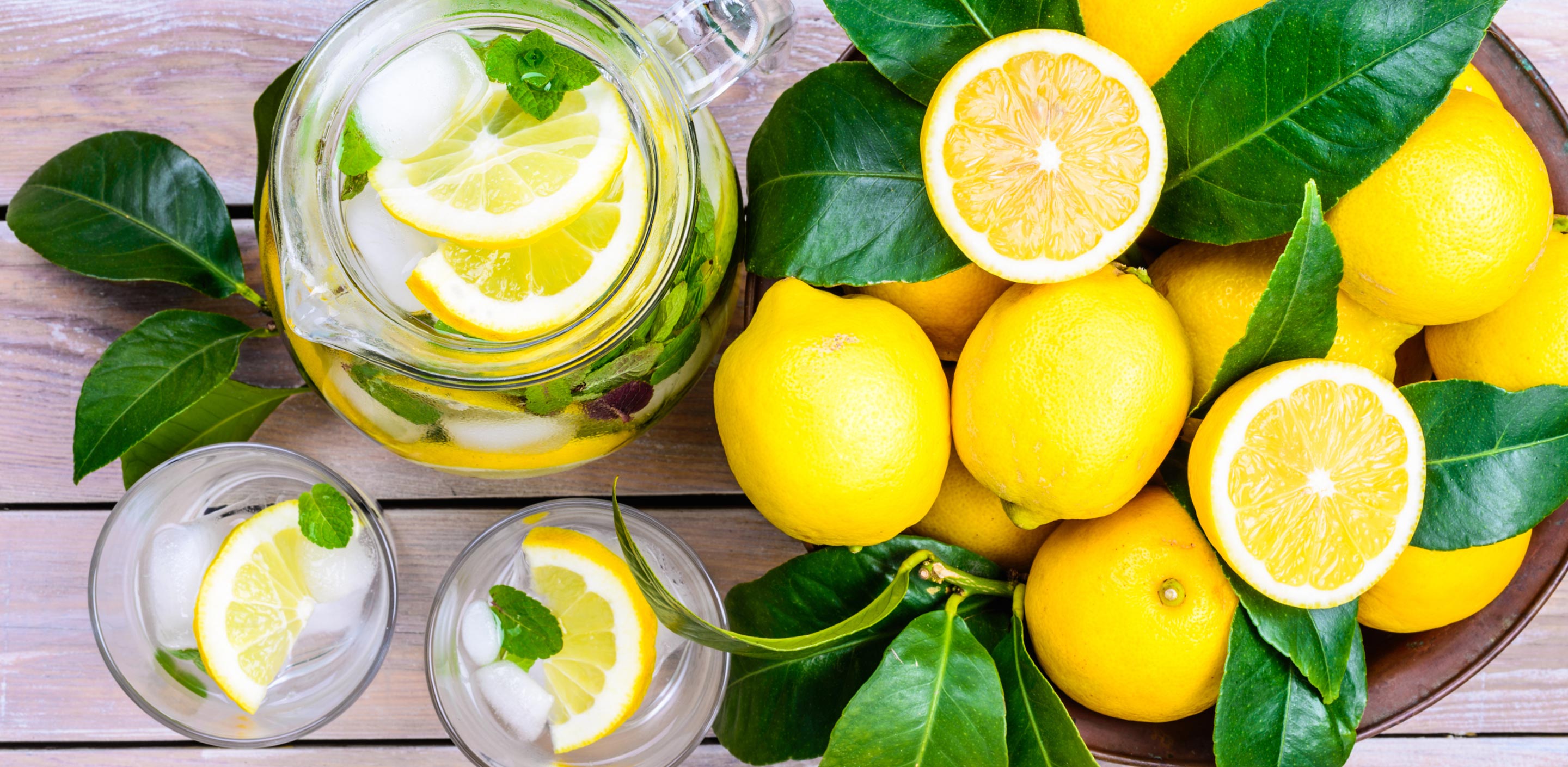 flat lay of lemons, pitcher of lemonade and glasses with mint